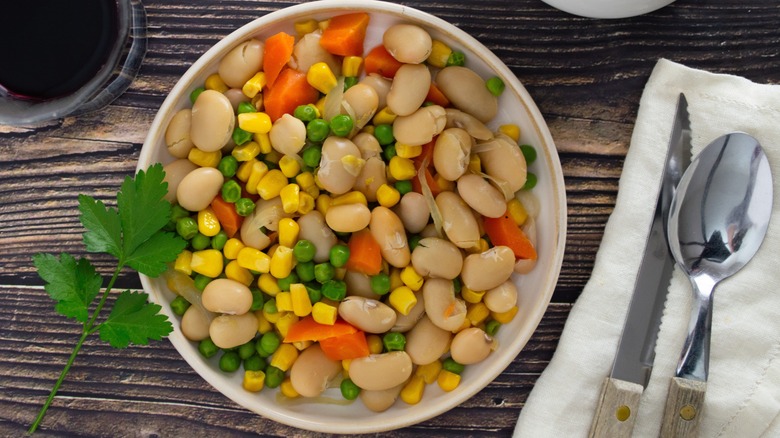 Succotash in bowl on table with cutlery
