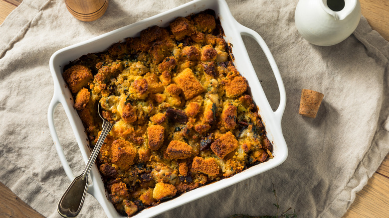 A tray of baked oyster stuffing, with a serving spoon