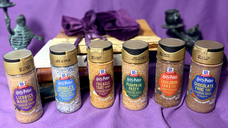 Six jars of Harry Potter finishing sugar flavors in front of purple background