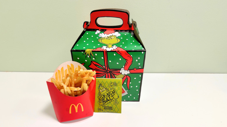 McDonalds fries and a Grinch Salt packet sit in front of a Grinch meal box