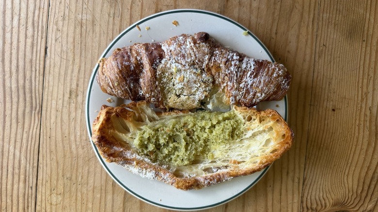 Flaky pistachio croissant on white plate