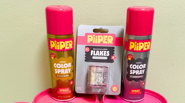 Two cans of PiiPER Color Spray and a container of PiiPer Decorate Edible Flakes