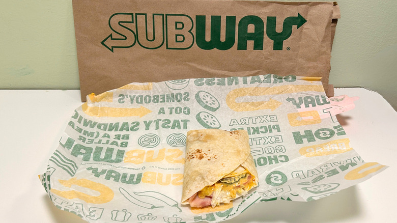 Turkey Ham Protein Pocket on a wrapper in front of a Subway bag