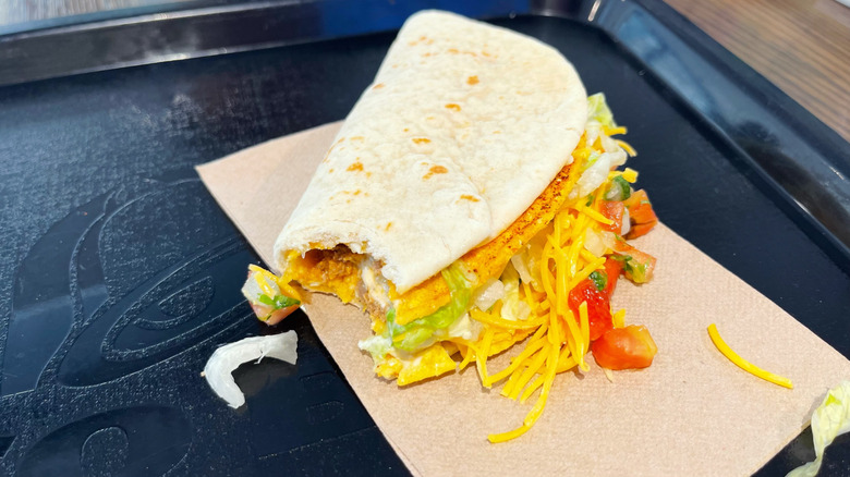 The Tajín Cheesy Gordita Crunch with a bite taken out of it on a black trey