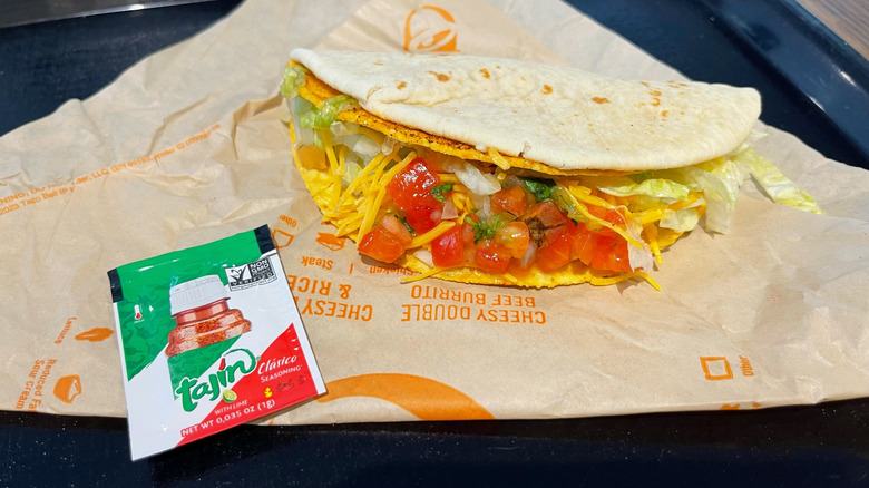 The Tajín Cheesy Gordita Crunch over a paper with a Tajín packet