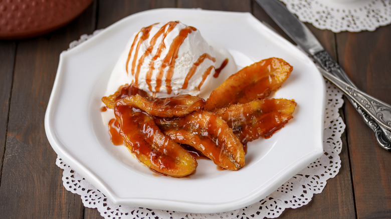Bananas foster with ice cream on a white plate