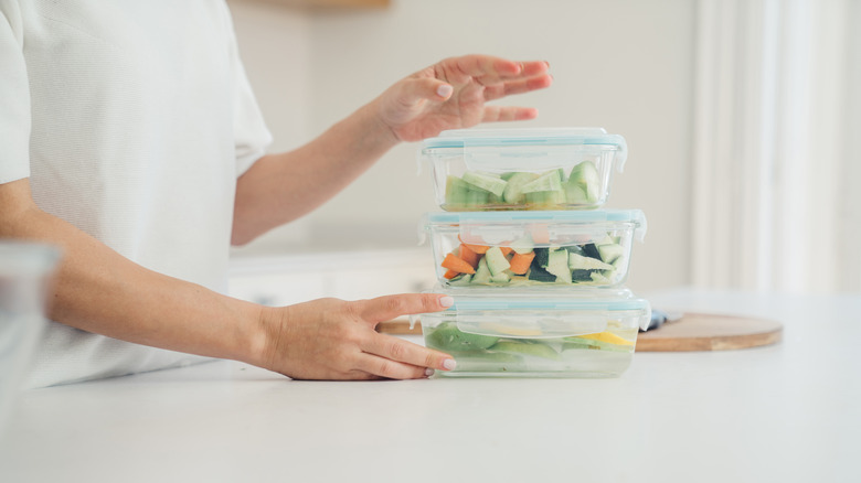 Three food storage containers stacked with vegetables