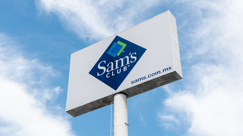 The Sam's Club logo on a tall billboard against a bright blue sky
