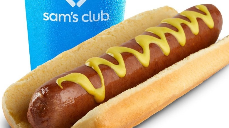 a hot dog with mayonnaise and a Sam's Club cup in the background