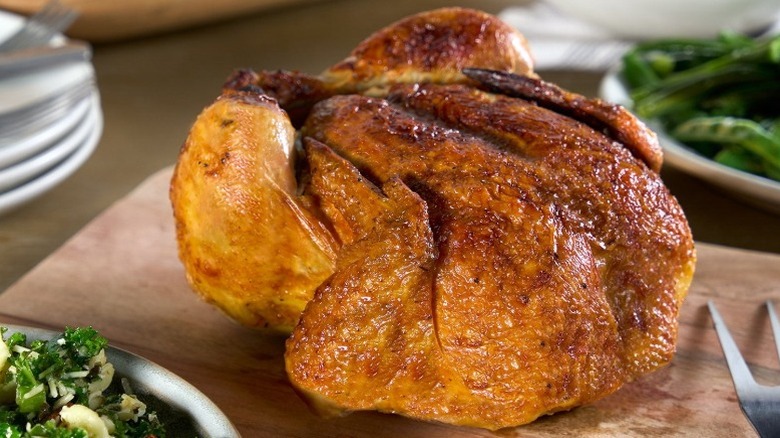 a whole roast chicken on a cutting board
