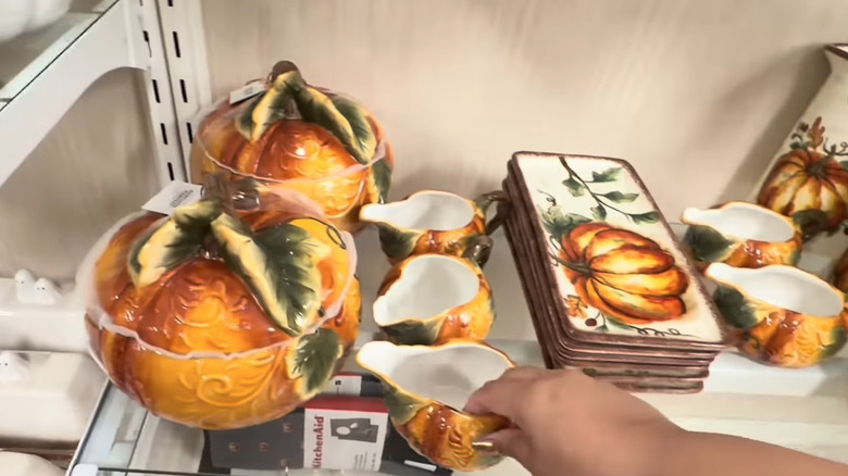 Glass shelf holding pumpkin cookie jars, creamer bowls, platters