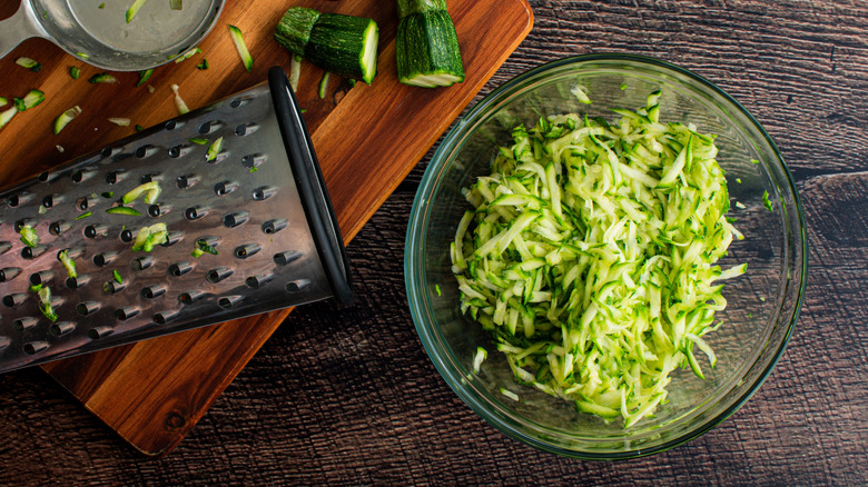 Shredded zucchini in bowl with box grater