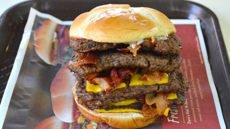 A Baconator with four patties on a tray.