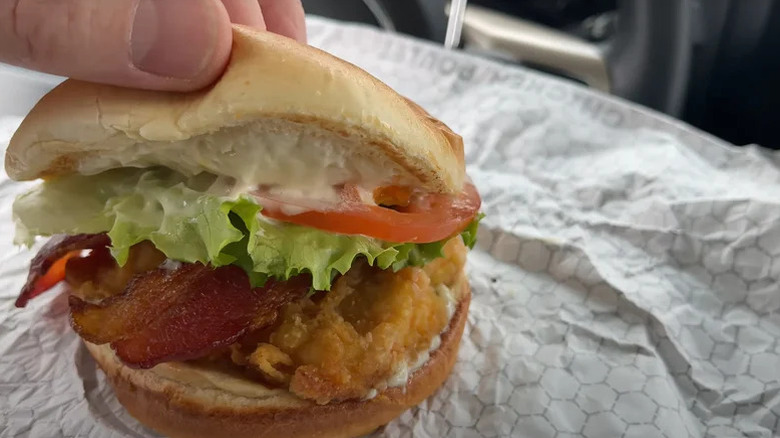 A closeup of a person's hand opening a Valley Crispy Chicken Club