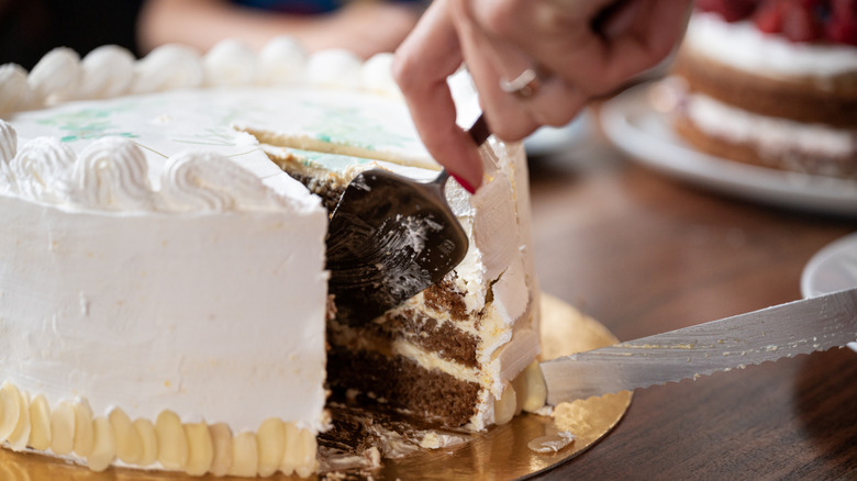 someone cutting a slice of cake