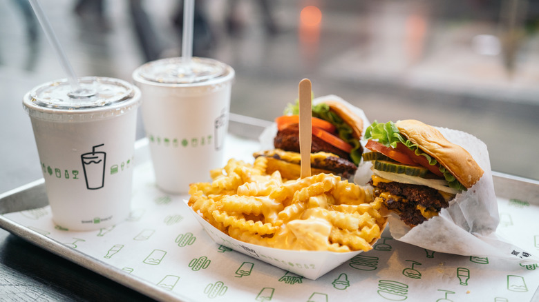 burgers, cheese fries, and beverages on a tray at Shake Shack