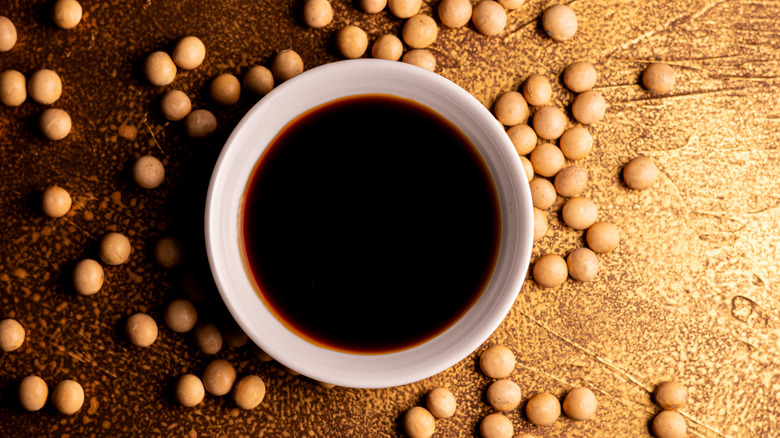 A bowl of shoyu placed on a rustic wooden table