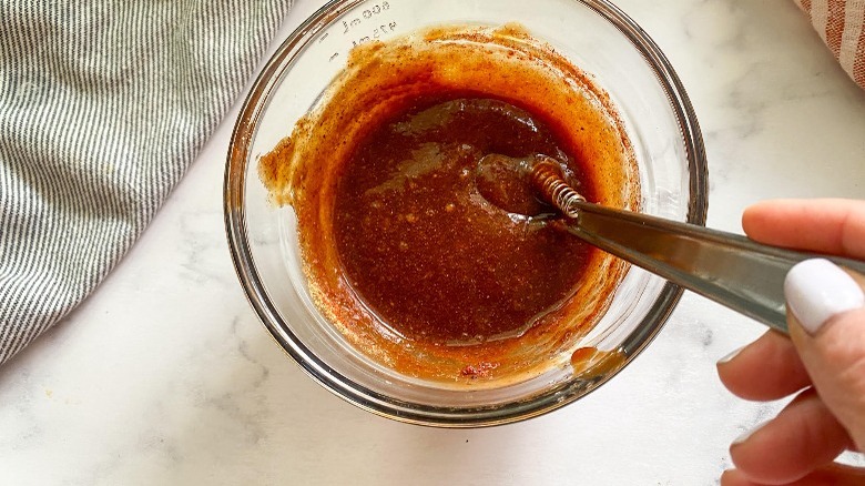 mixing sauce in glass bowl