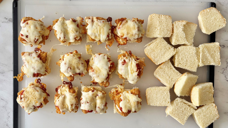 Chicken parmesan sliders next to top buns