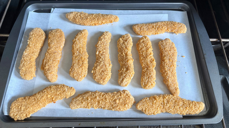 Breaded chicken strips on baking sheet