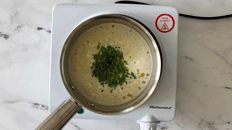 Melted butter and chopped parsley in saucepan