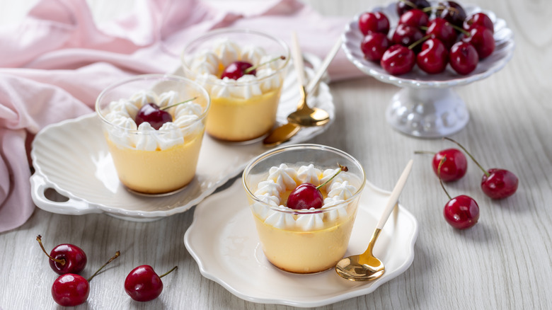 Flan with whipped cream and cherries.