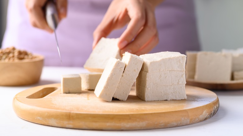 Slicing tofu block on cutting board