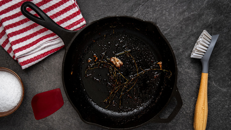Dirty cast iron pan on counter with salt