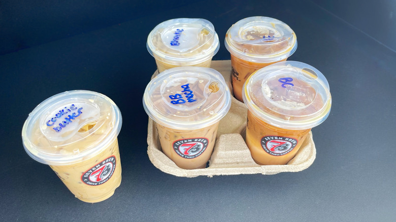 Four 7 Brew coffee drinks in a holder with one more on the side
