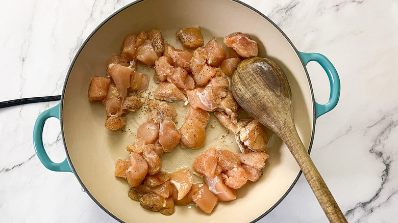 cubed chicken cooking in skillet
