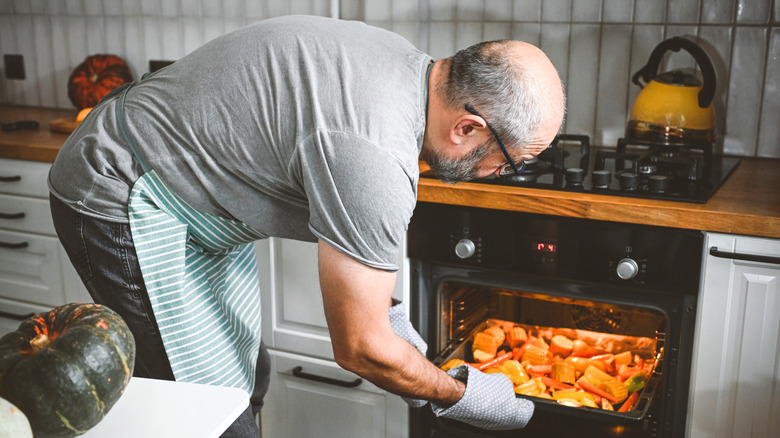 Man reheating food in oven