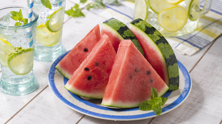 Watermelon slices on a plate, with glasses of lemon/lime/mint spa water