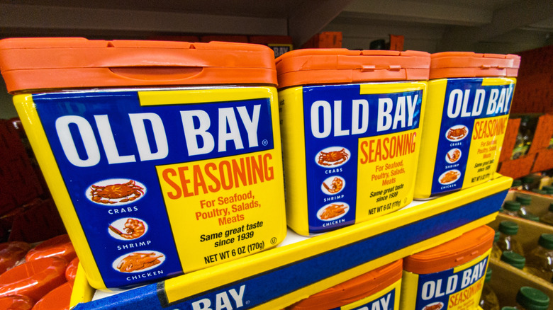 Rectangular red, yellow, and blue containers of Old Bay seasoning