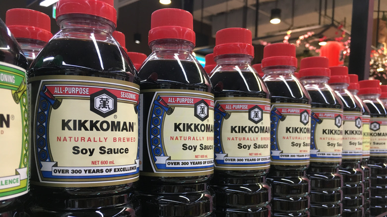 Tall plastic bottles of Kikkoman Soy Sauce on a shelf