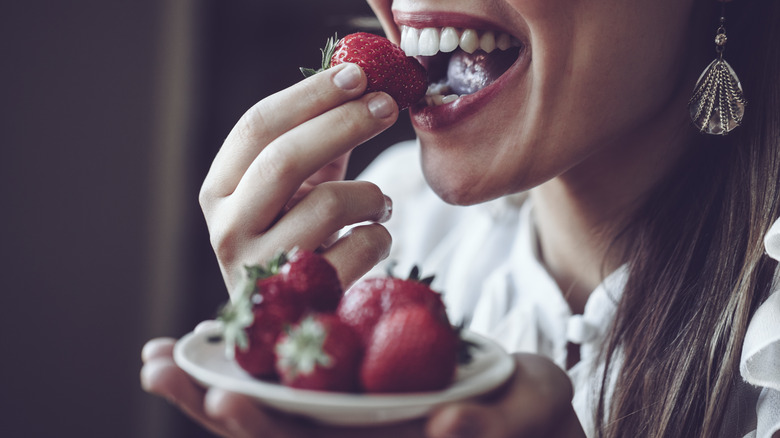 Young woman eating strawberries