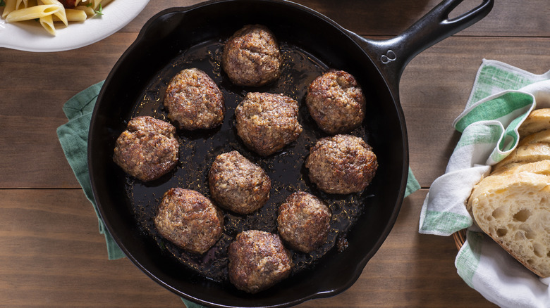 Meatballs in cast iron pan with bread and pasta
