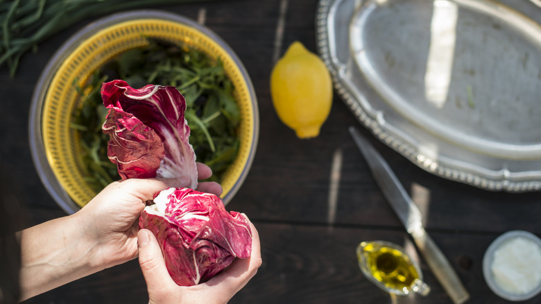 Hands placing veggies into a salad spinner