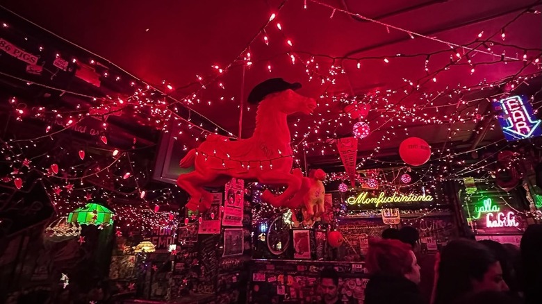 Carousel horse in red lit-up interior of Montana bar