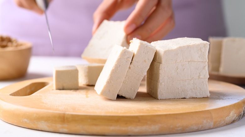person cutting tofu into cubes