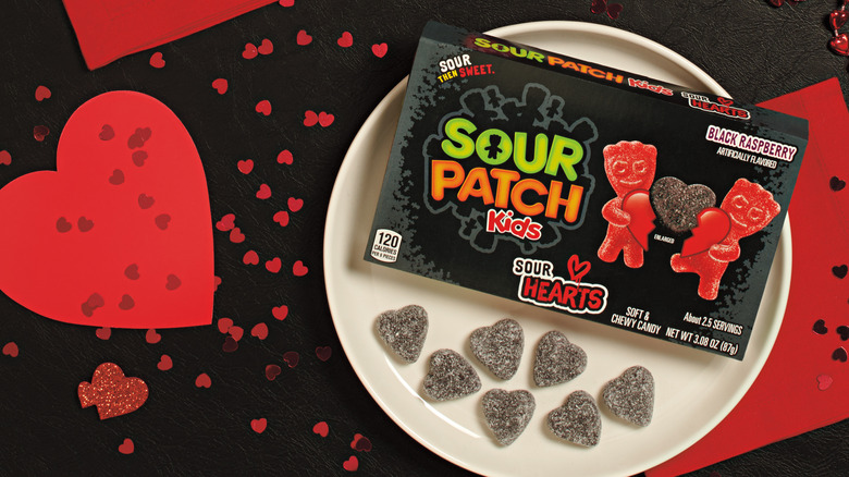 Sour Patch Kids Sour Hearts gummies on a plate with box