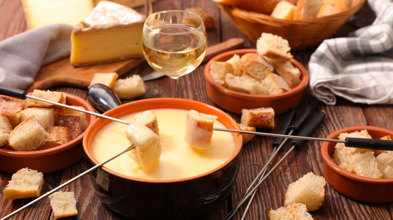 A crock filled with beer cheese fondue and bread dippers