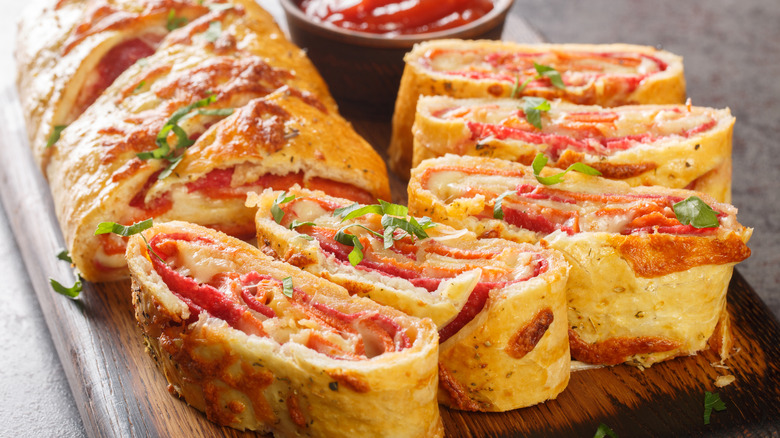 A wooden cutting board with sliced West Virginia pepperoni rolls