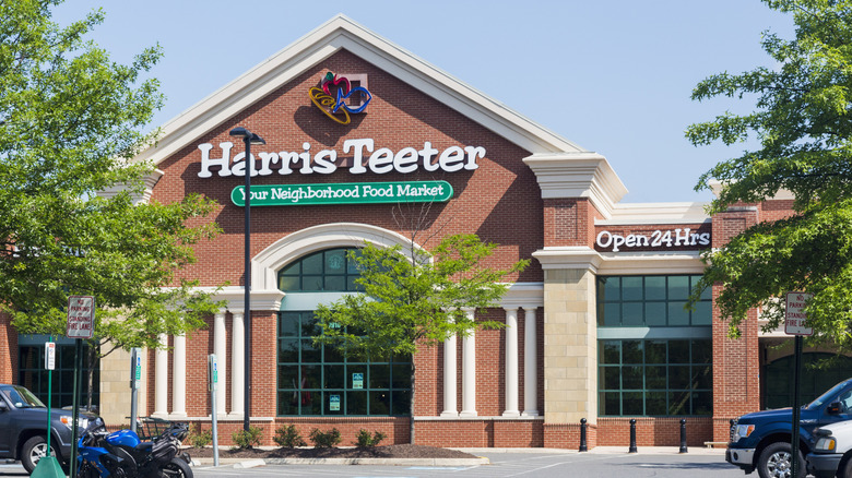 View of an elegant brick Harris Teeter storefront with trees in the parking lot