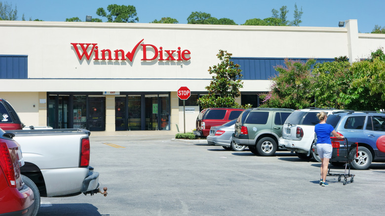 View from the crowded parking lot of a Winn Dixie grocery store façade