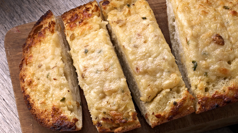 Garlic cheese bread slices on board 