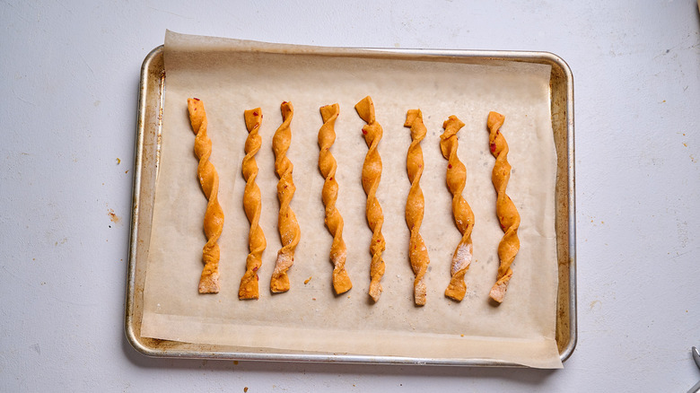 dough strips twisted into straws on a sheet tray