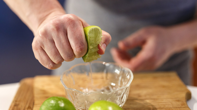 hands squeezing lime into bowl