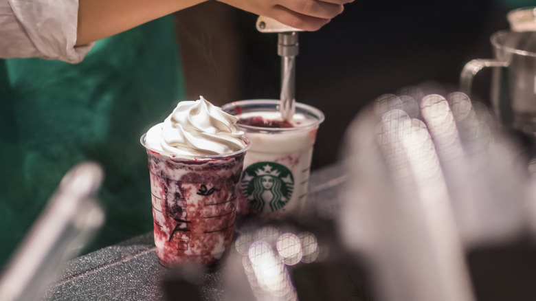 barista putting whipped cream on drink
