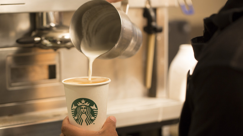 Starbucks barista pouring steamed milk