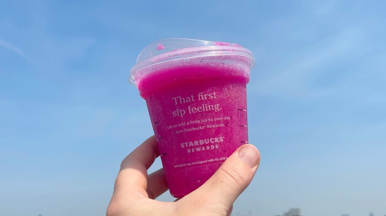 The mango dragonfruit Refresher held towards the sky